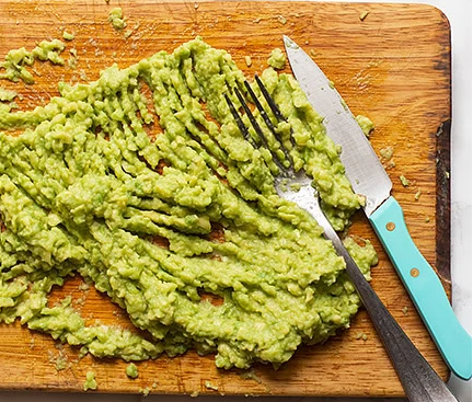 schiacciare l'avocado per la guacamole